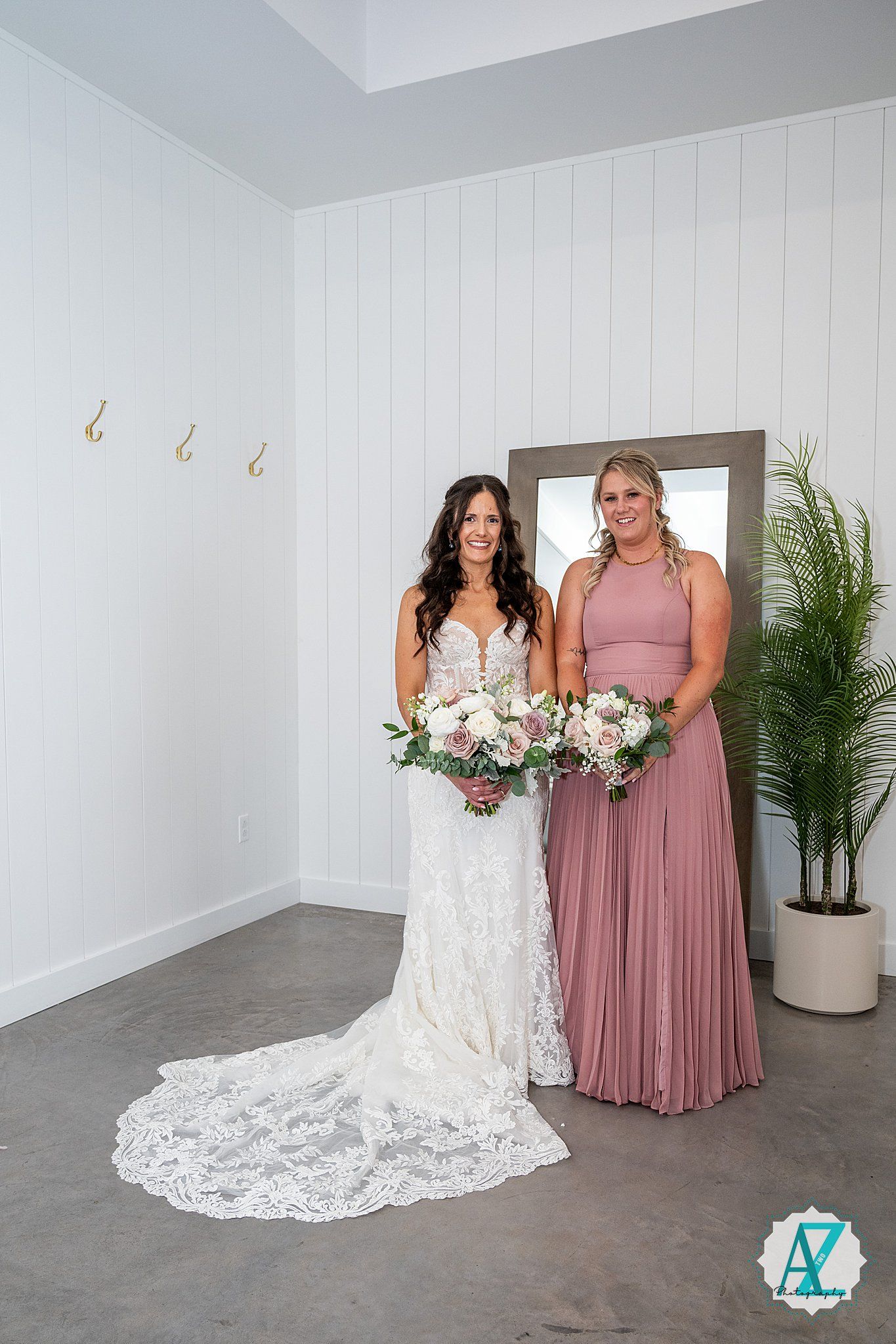Wedding photo series showing moments with a bride in lace gown posing with attendant in dusty rose dress.