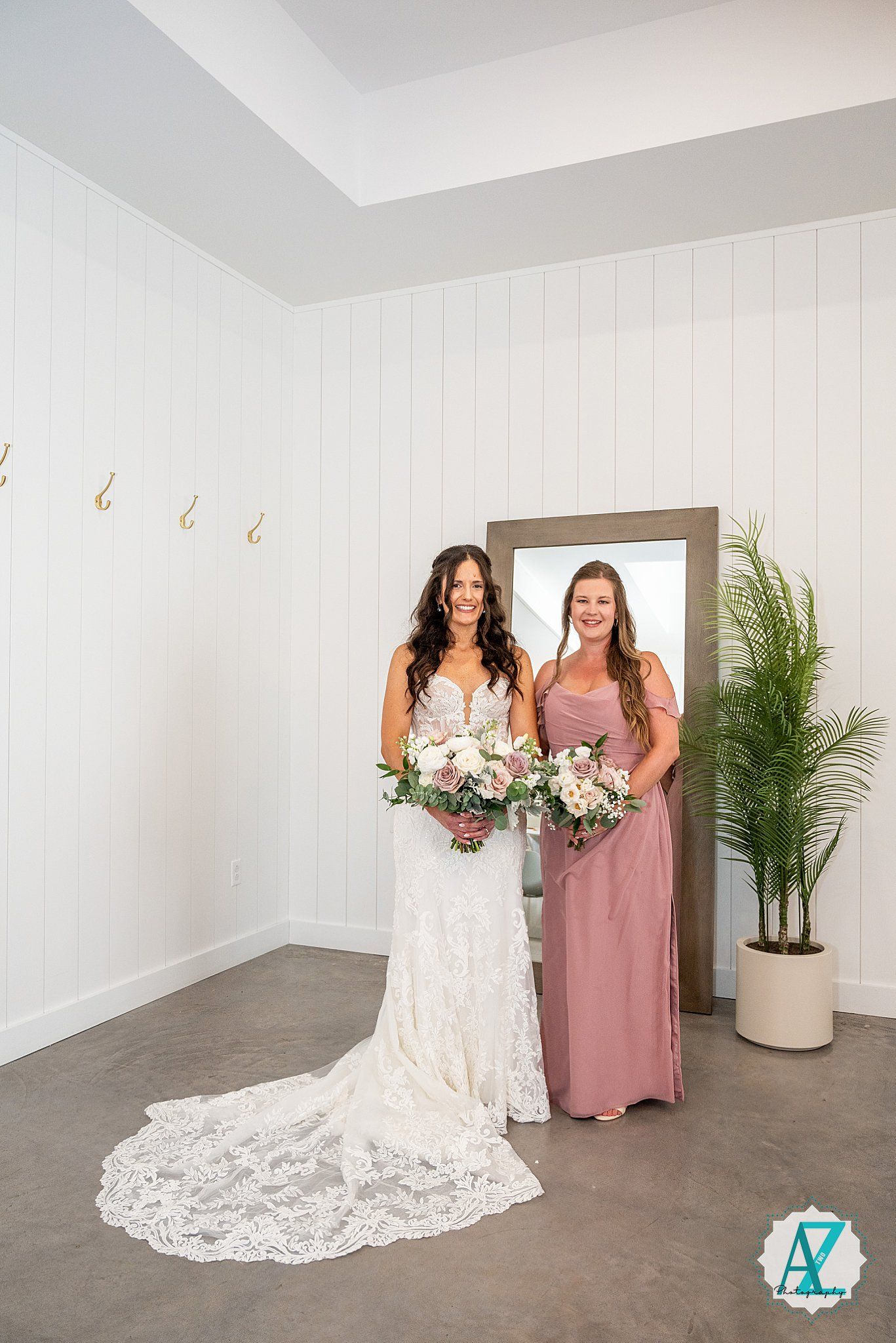 Bridal party portrait session in modern white venue with pink and white floral details.