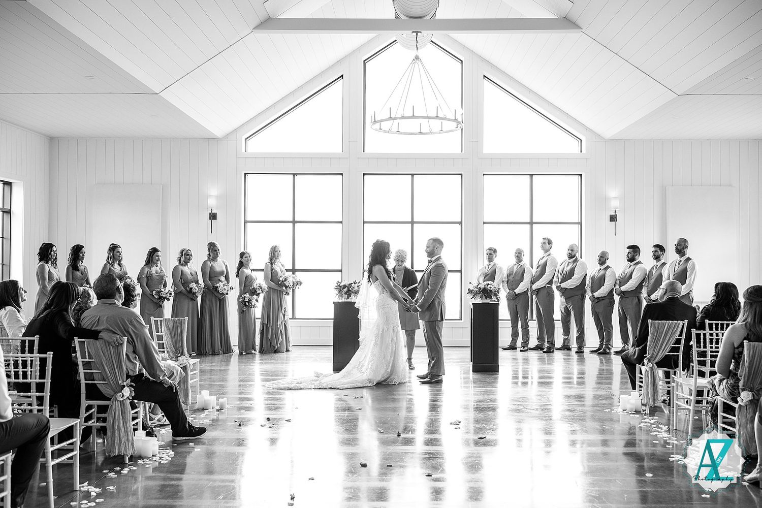 Wide angle view of wedding guests seated in rows during an indoor ceremony.