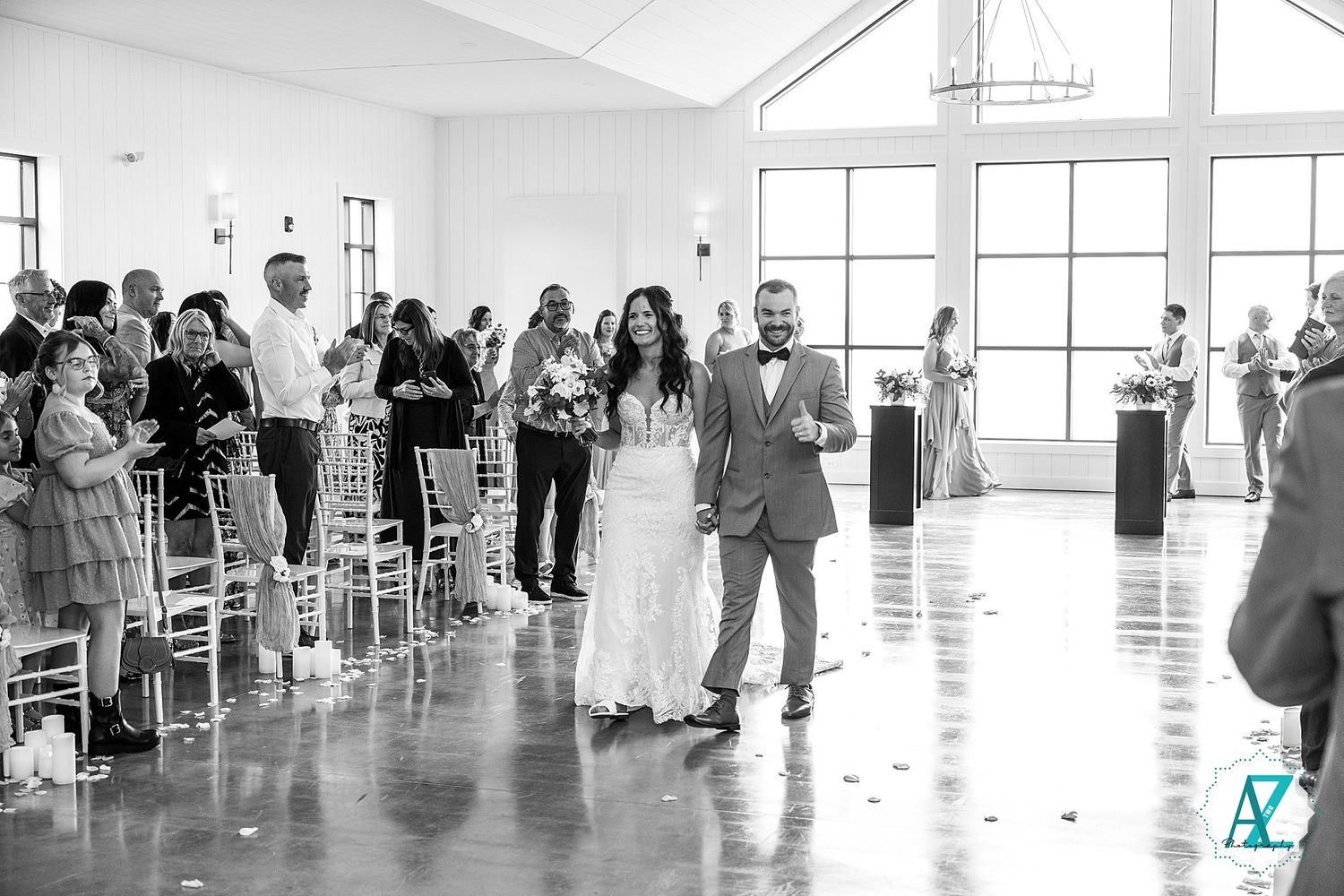 A group of people standing in line in an open, bright indoor space with white floors and walls as they wait for an event.