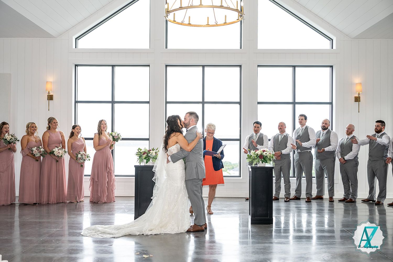 A bright, modern wedding venue with white walls, skylights and windows creates an airy atmosphere for celebration.