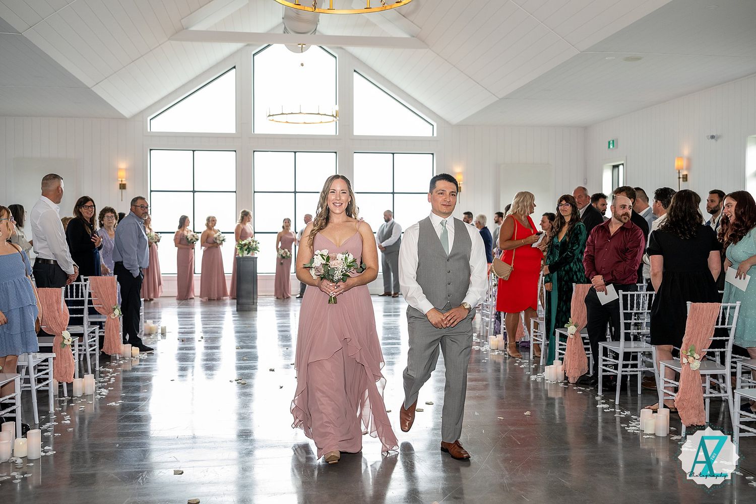 Elegant wedding ceremony setup in a bright white venue with rows of chairs and stylish decor for guests.
