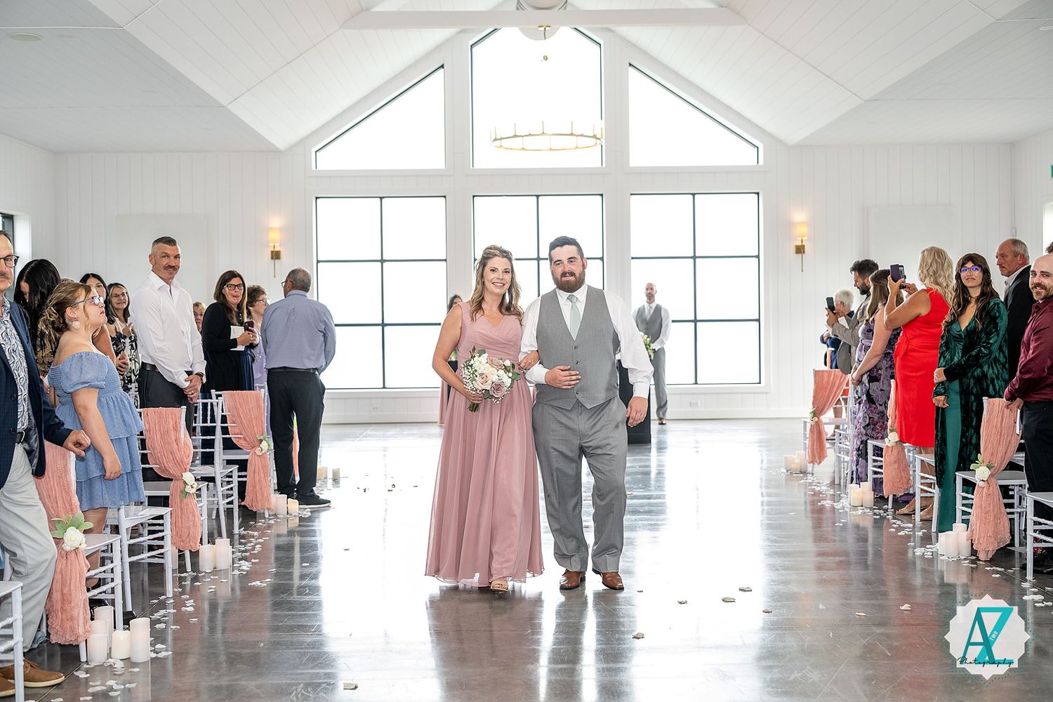 Guests gather in a sunlit wedding venue with white walls and contemporary architectural details.