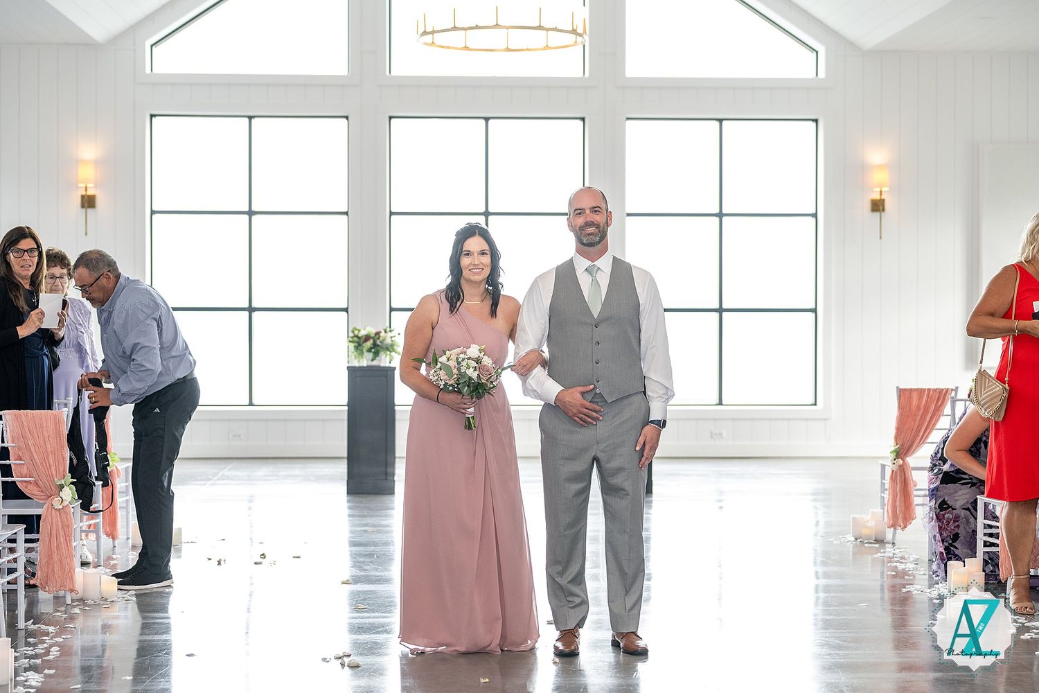 Wedding party in pink dresses and gray suits poses in series of candid moments inside bright white venue.