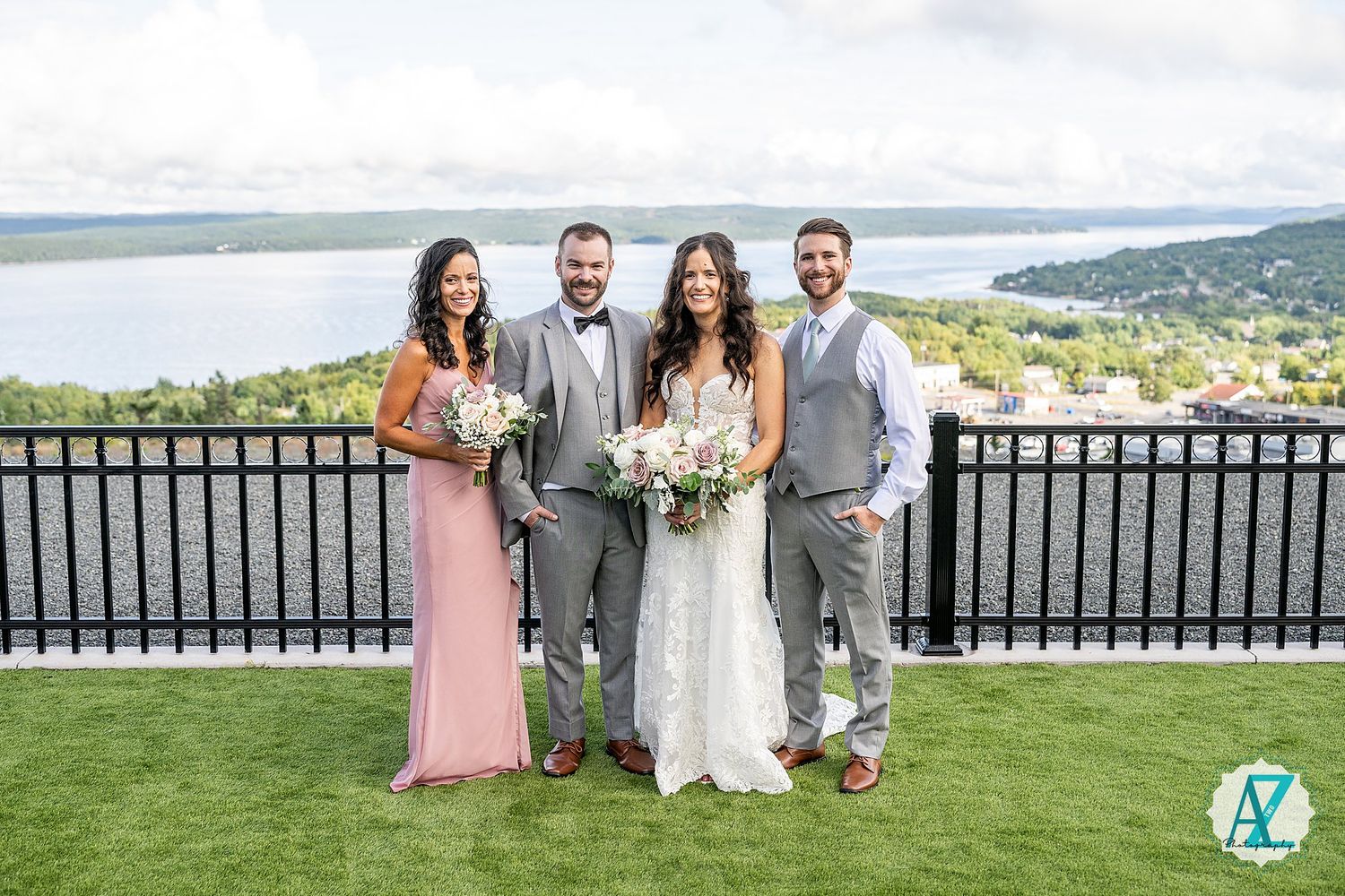 Wedding celebration on an outdoor terrace with mountain lake views and elegant black railings.