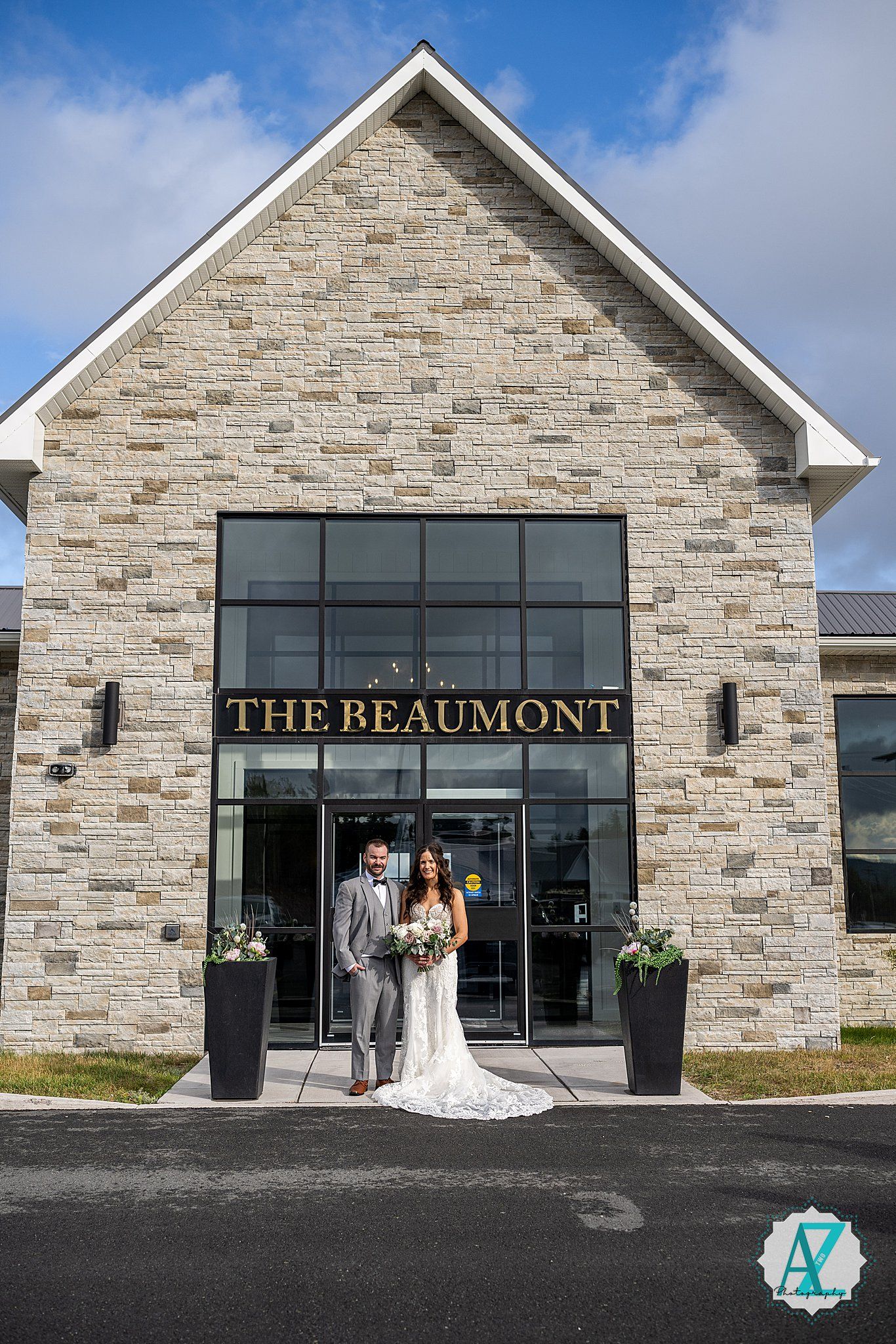 The exterior of The Beaumont venue features modern stone architecture with large glass windows and signage.