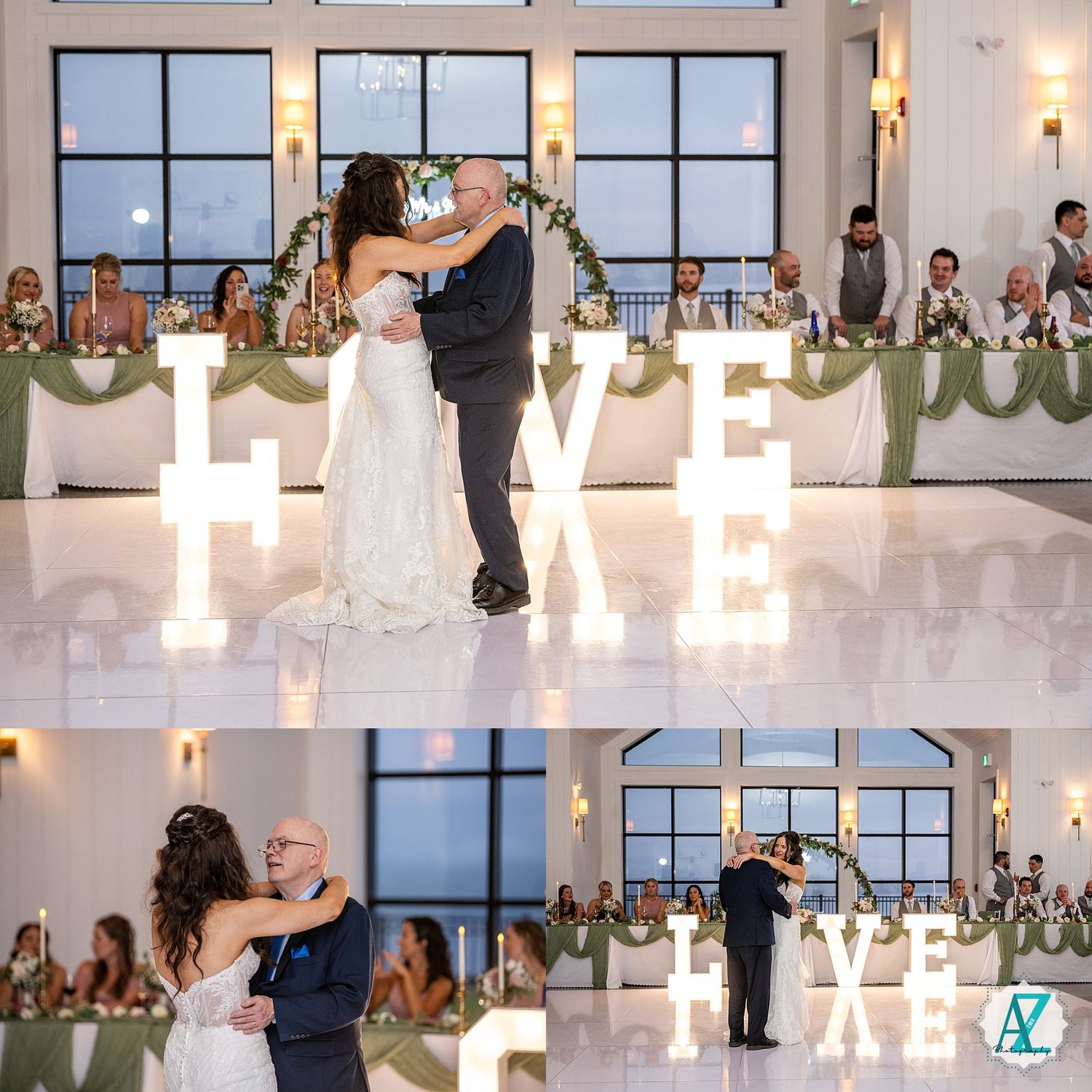 Wedding guests gathered in an elegant ballroom with large windows dance and celebrate during an evening reception.