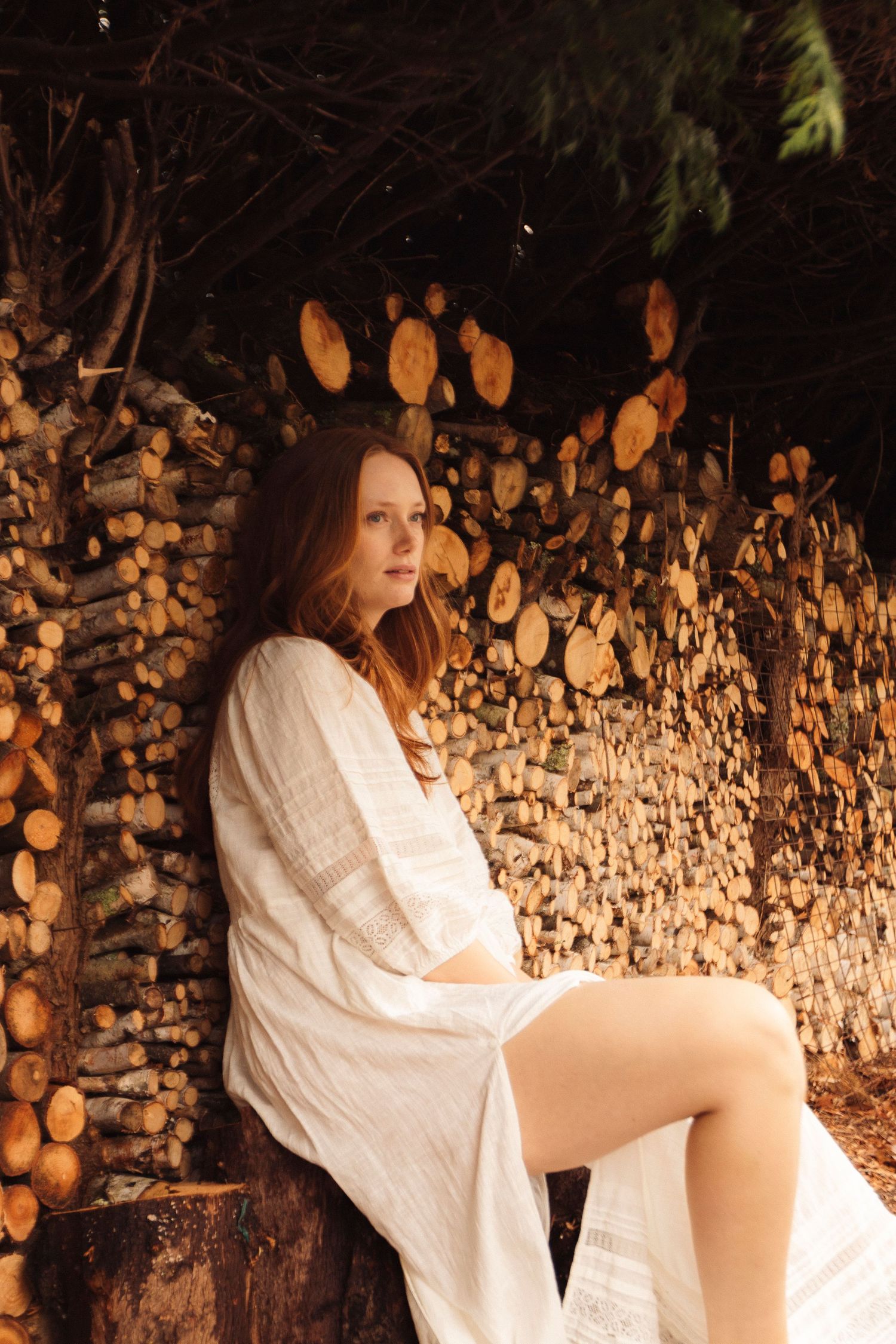 A figure in white dress appears to fall and spin across a series of motion-blurred photos against a stone wall backdrop.