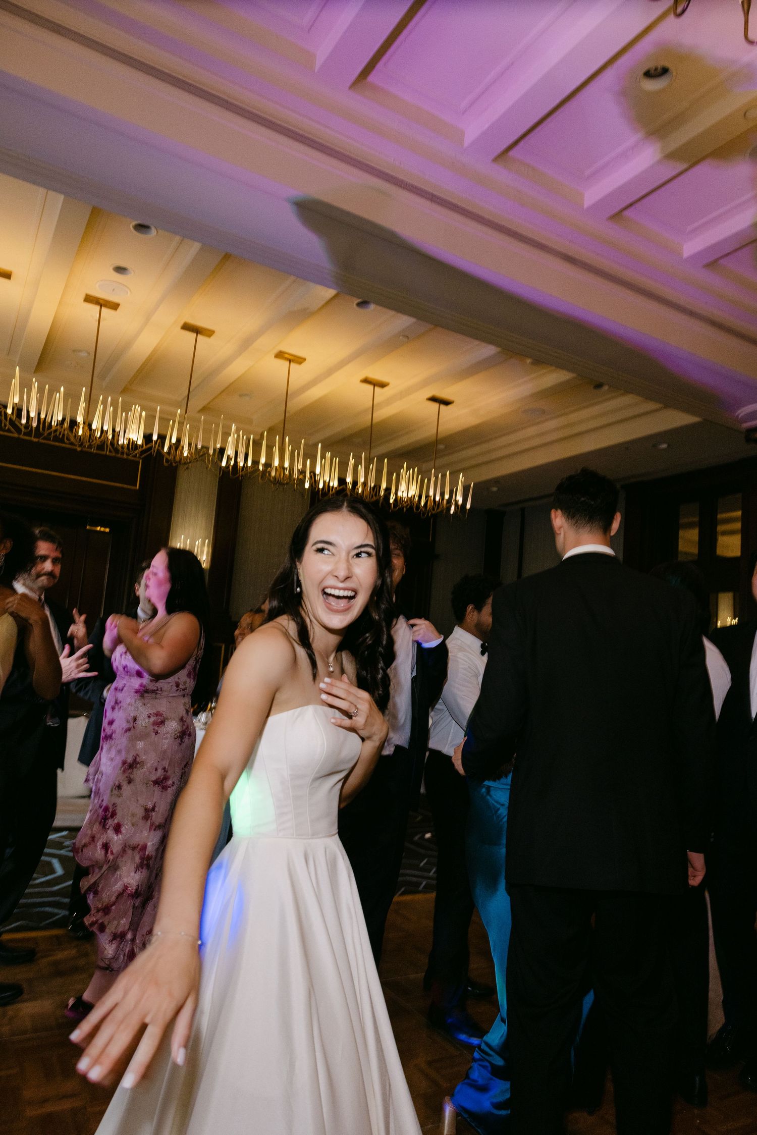 A candid reception moment showing pure joy and laughter on the dance floor.