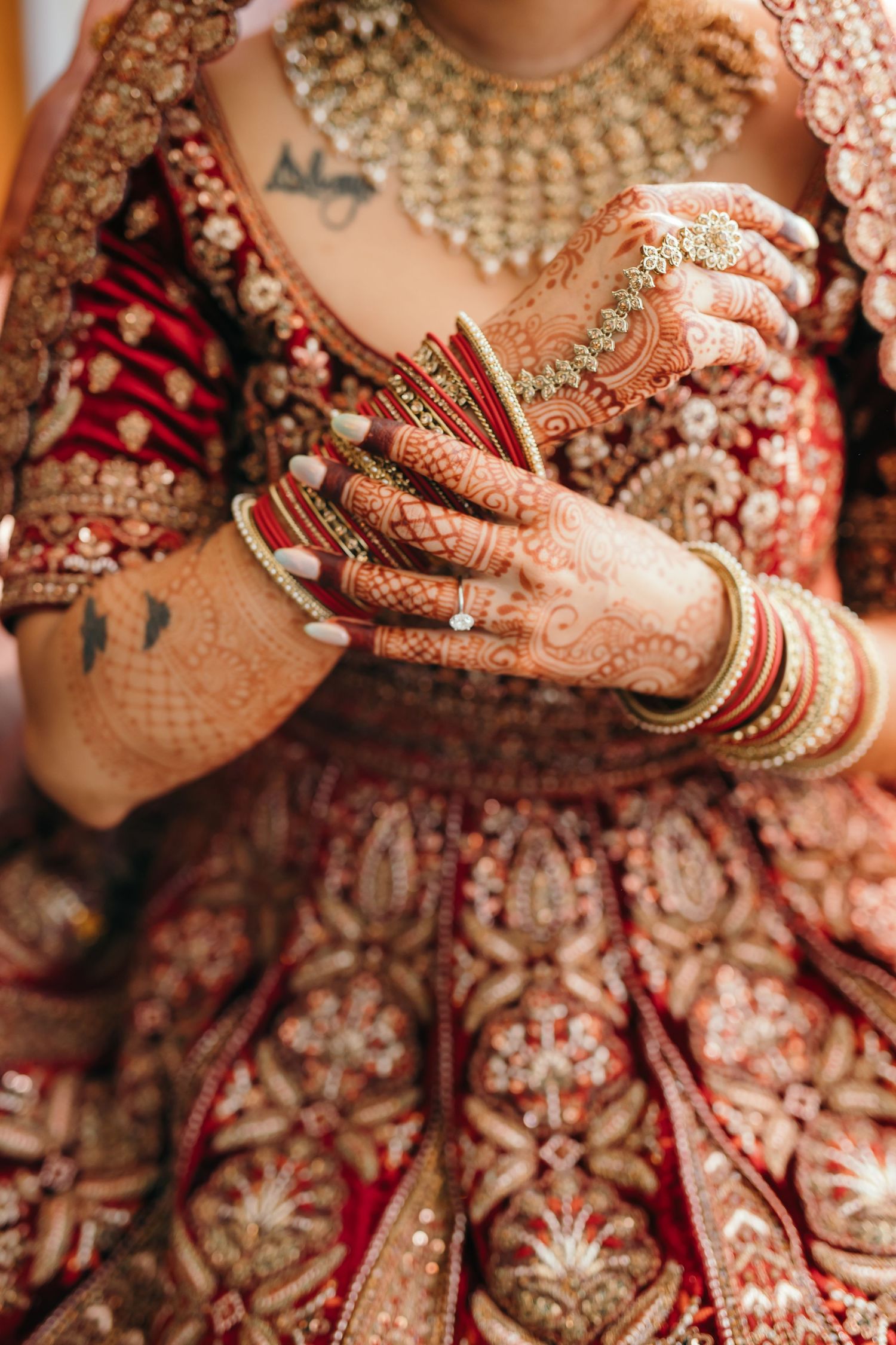 Intricate bridal details showing traditional Indian wedding attire and henna decorated hands.
