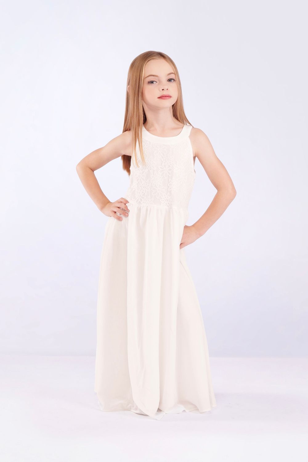 Young dancer in flowing white dress strikes elegant poses in studio setting.