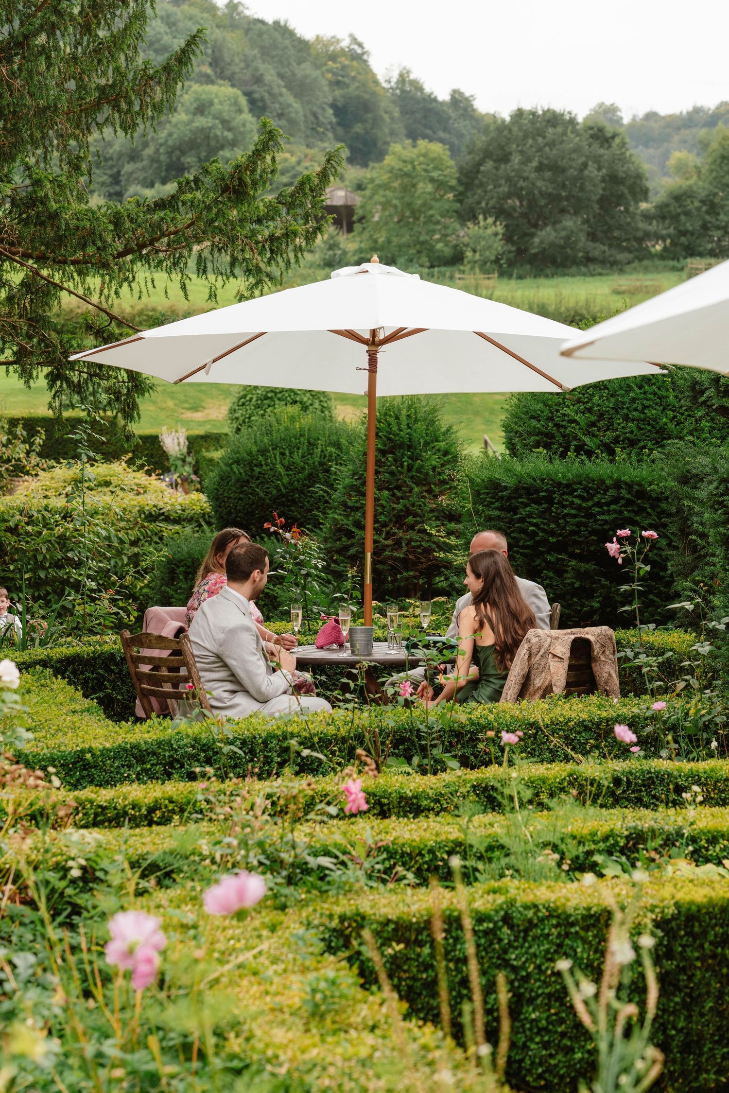 Owlpen Manor Weddings Photographer Zara Davis Photography Cotswolds Uley Cheltenham Gloucestershire guests at table in garden manor house