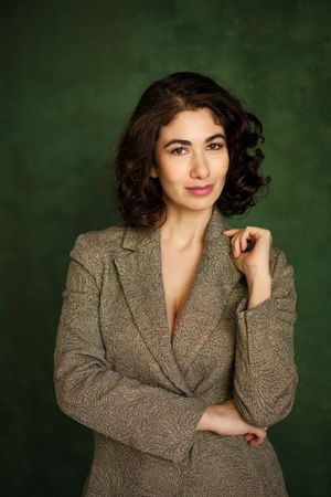 Stylish portrait series showcasing a tweed blazer against a deep green background.