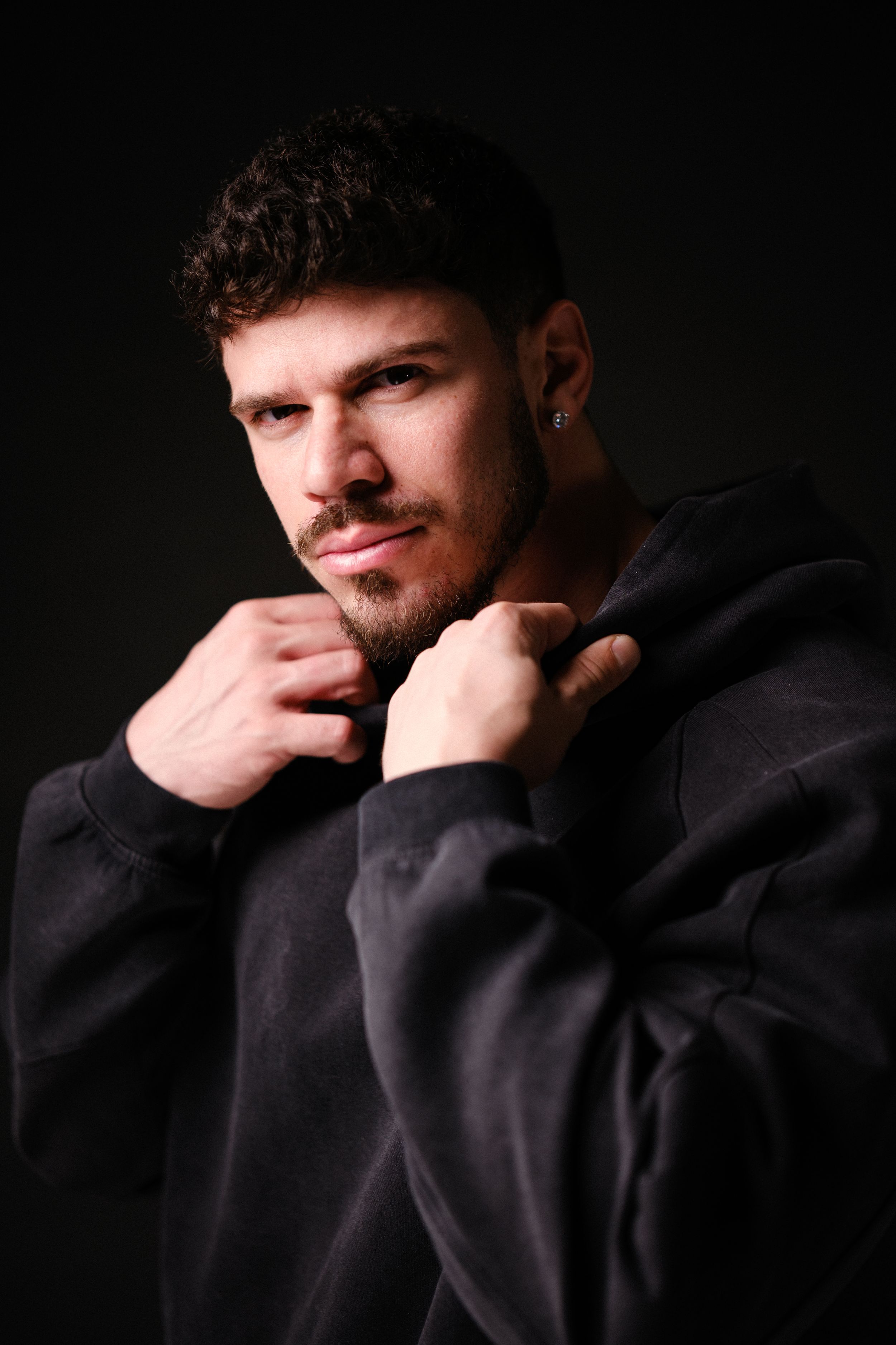 Moody portrait series with dramatic lighting showing contemplative poses in black.