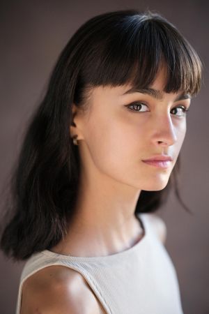 Soft portrait series with side lighting showcasing a white top against neutral background.