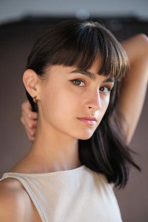 Close-up portrait series showing different angles of someone with dark bangs wearing a white ribbed top.