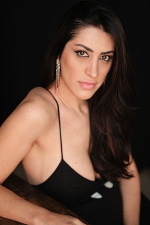 Glamour portrait series against a black background featuring a black spaghetti strap top.
