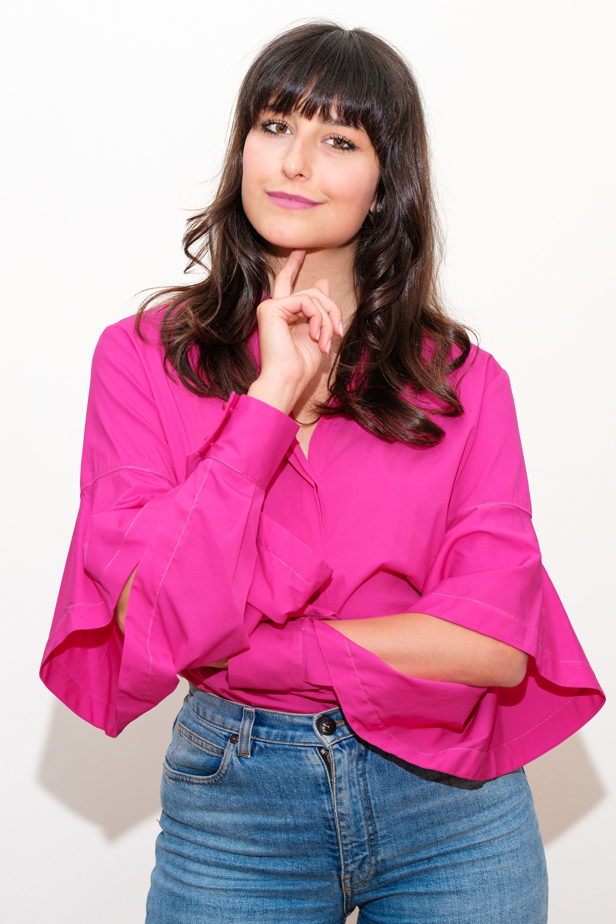 Fashion series with bright pink top and jeans against white background showing casual poses.