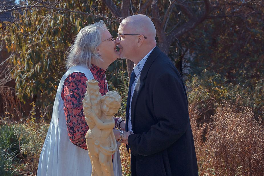 A collage showing multiple romantic outdoor wedding moments in fall foliage with a happy couple embracing and kissing.