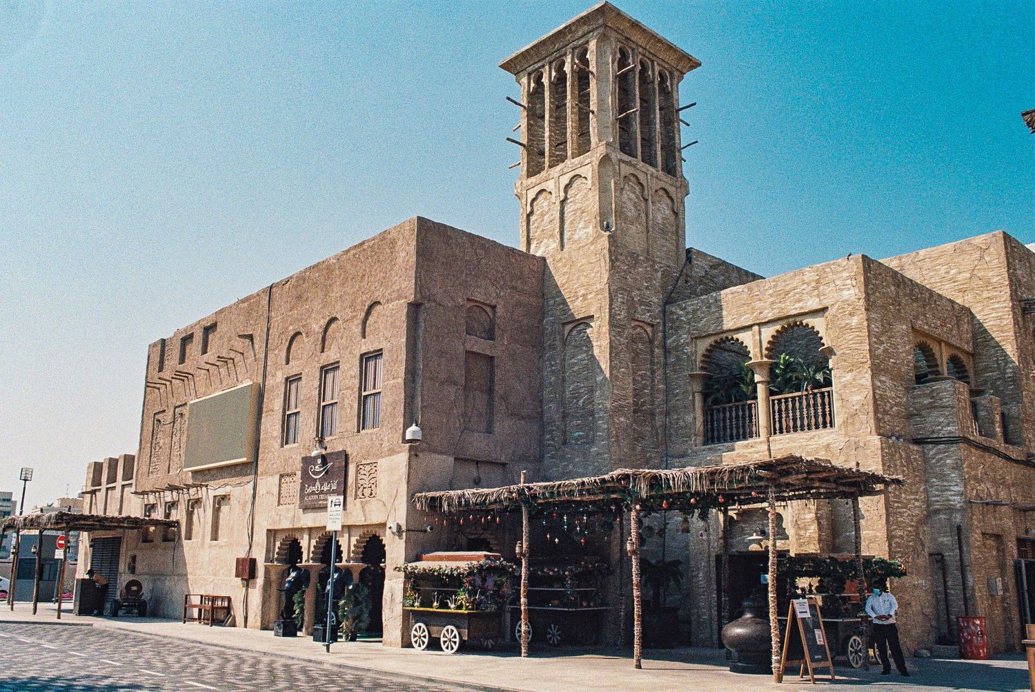 Traditional stone building with wind tower in Dubai's historic Al Bastakiya district features historic Arabian architecture.
