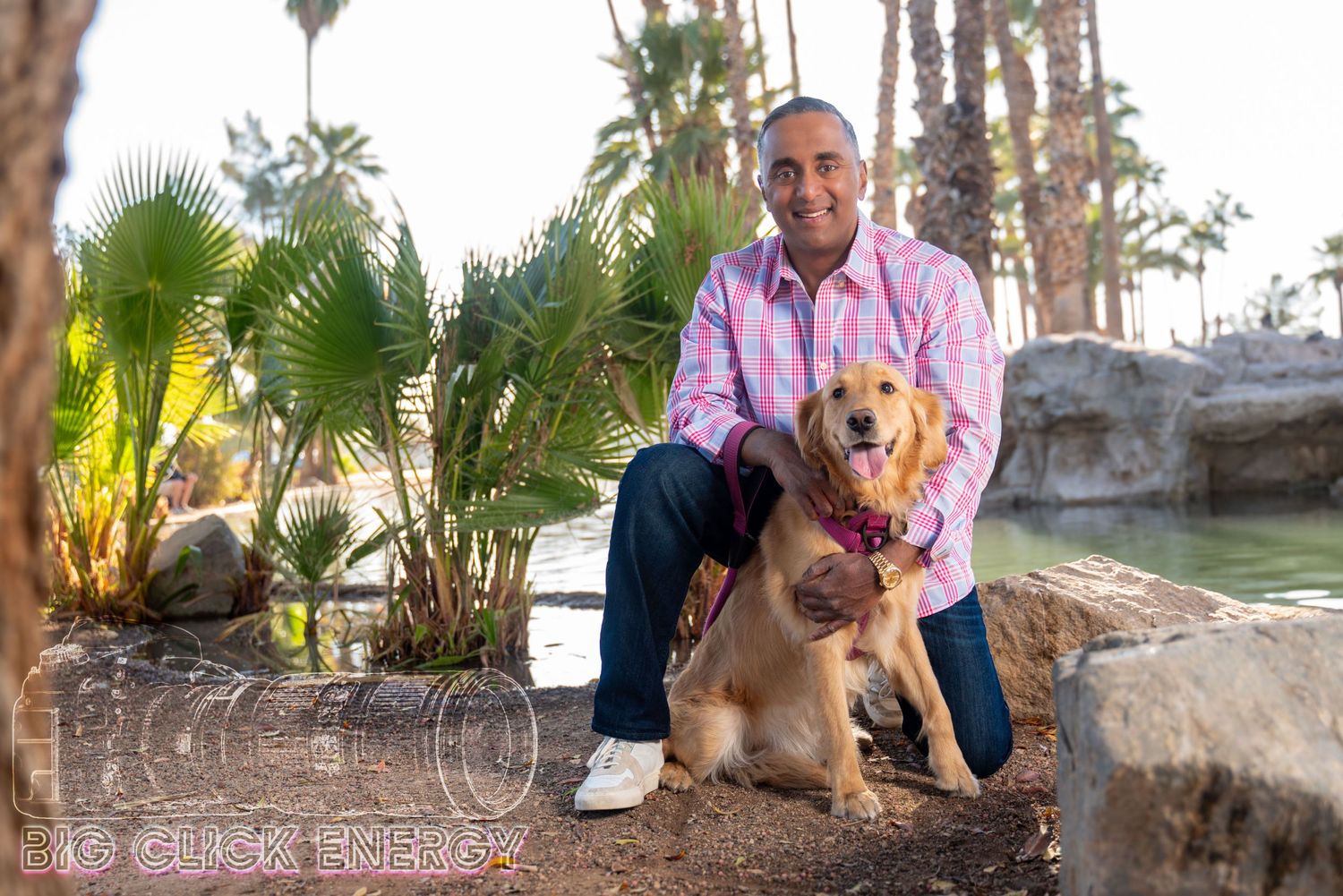 A man kneels on a sunlit park path, his golden retriever by his side. His relaxed confidence makes for a great dating profile shot.