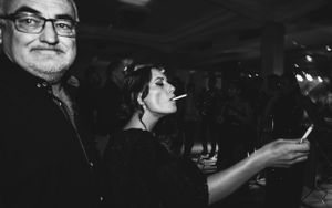 Dokumentarna fotografija na dan venčanja
Žurka na svadbi i kuma kako pali cigaretu sa čovekom u uglu fotografije
Crno bela fotografija