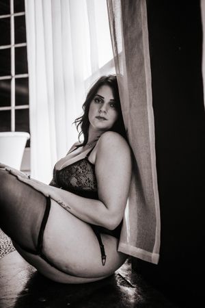 Artistic black and white intimate portrait by window.