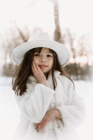 Three artistic winter portraits featuring white clothing and hats against a snowy background create a dreamy atmosphere.