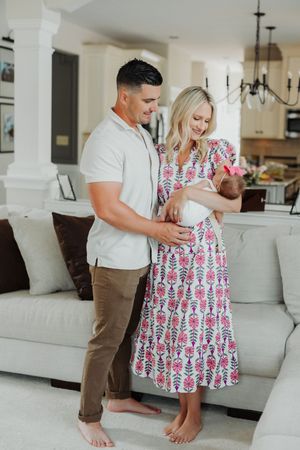 Couple embraces during a tender moment at home in a bright living room with white furniture.