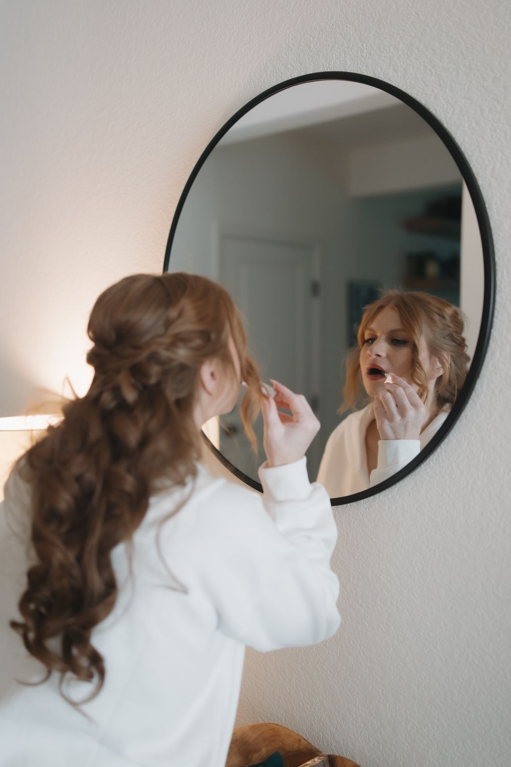 Getting ready scene reflected in round mirrors mounted on white wall.