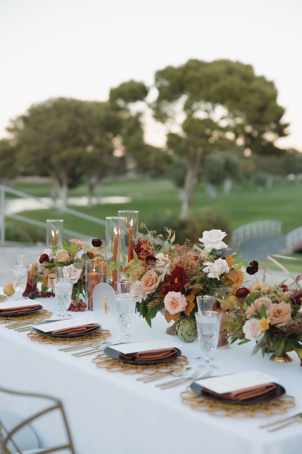 Long wedding reception table with elegant fall floral arrangements and place settings. Elegant Las Vegas Country Club reception table.