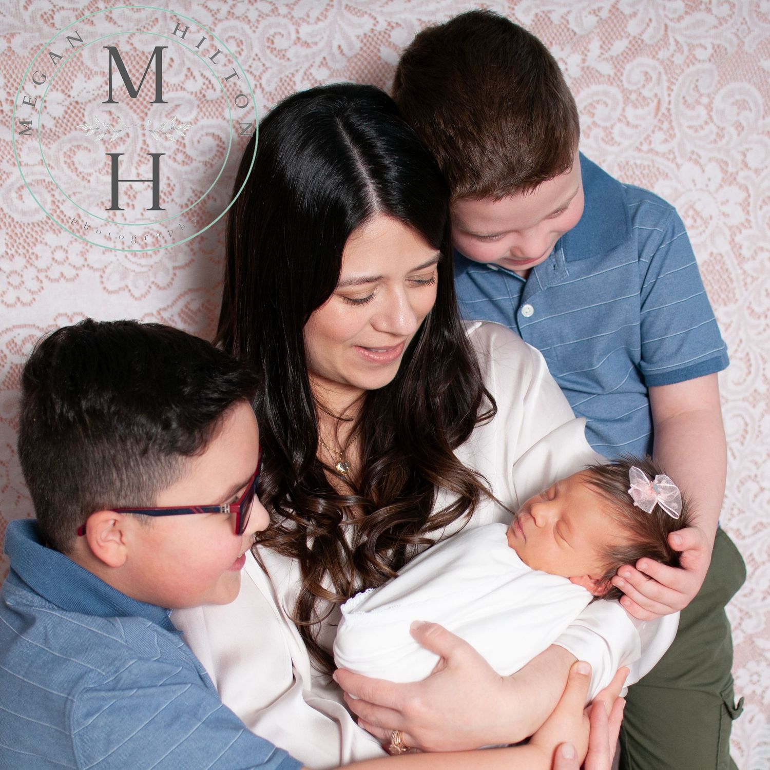 Mom with three kids candid photo looking at newborn