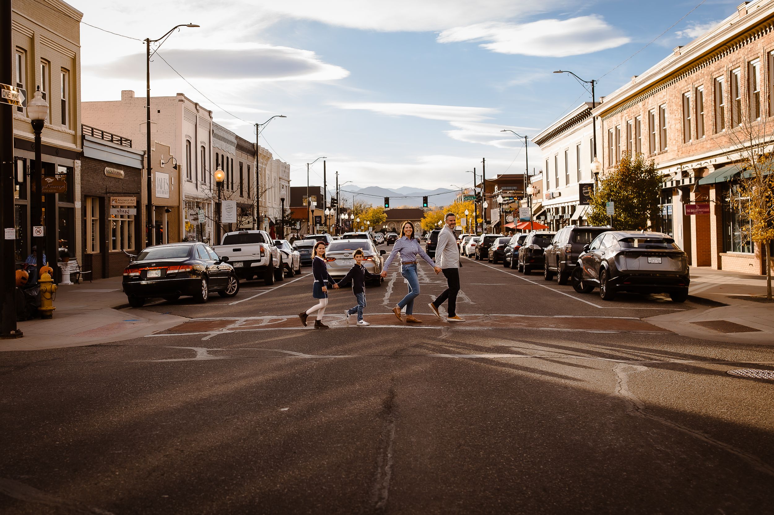 Family of four walking and smiling at golden hour in Littleton, Colorado