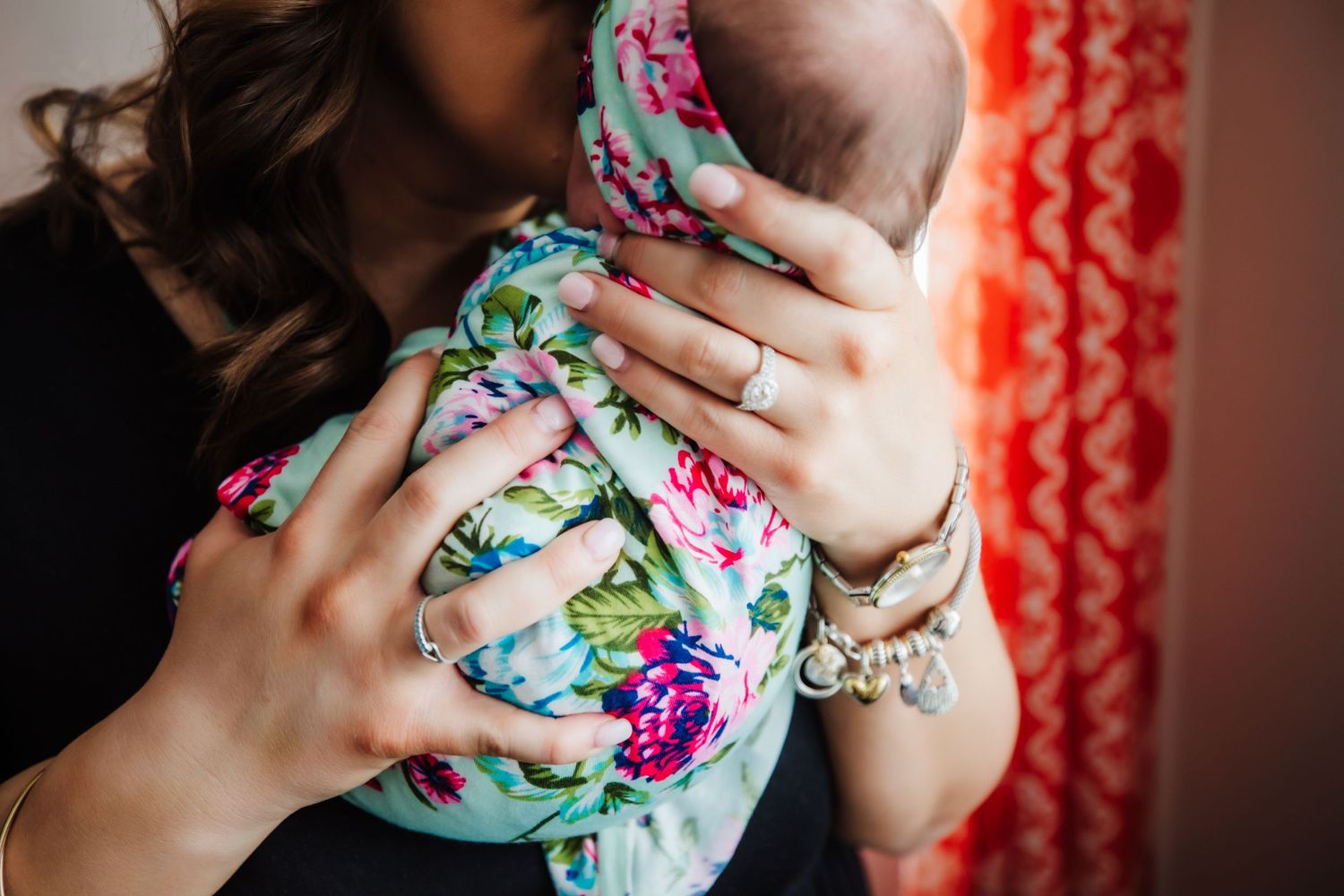 Mom holds newborn baby wrapped in floral blanket and headband in Dickson, TN