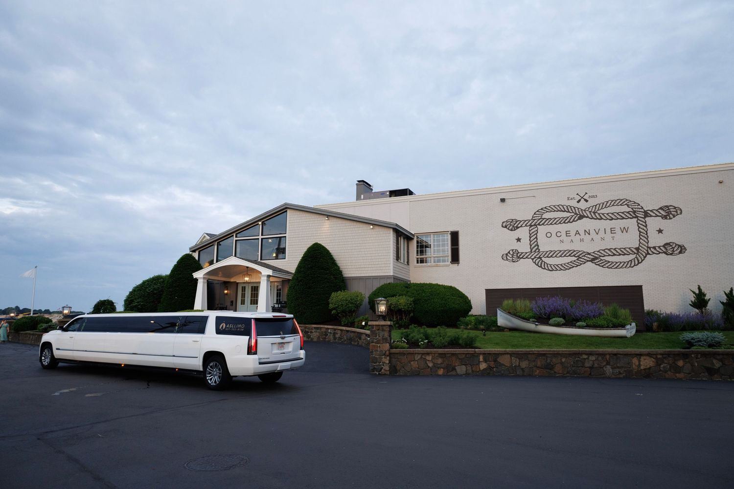 White stretch limousine parked outside the Oceanview banquet hall under a cloudy evening sky.