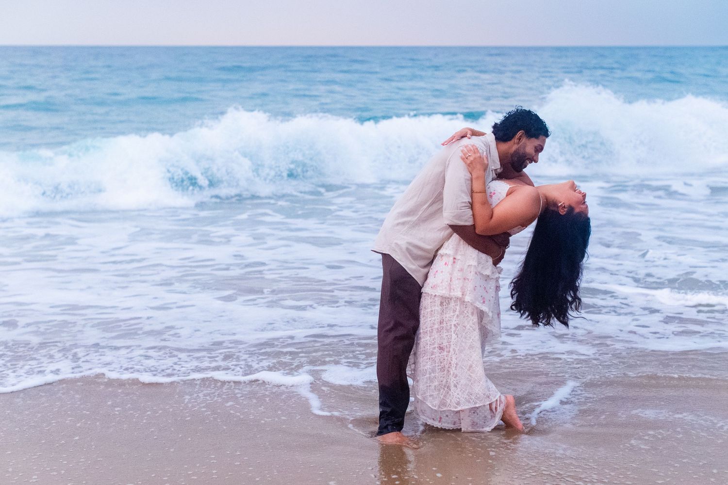Engagement portrait on the beach. Man and woman at the water's edge. Playa Guajataca, Isabela, Puerto Rico.