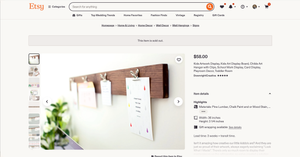 Rustic wood wall-mounted display board with metal clips holding notes and photos, shown in a modern home office setting.