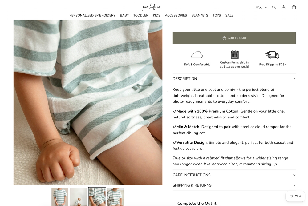 Baby boy wearing a light blue striped short sleeve shirt and white shorts, sitting on a white surface.