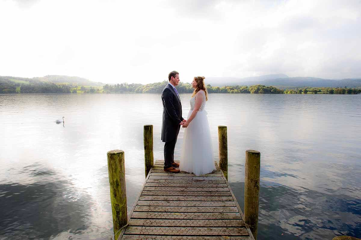 bride & groom stand on the jetty at the glorious Lansdale Chase Hotel situated near Windermere the lake district
