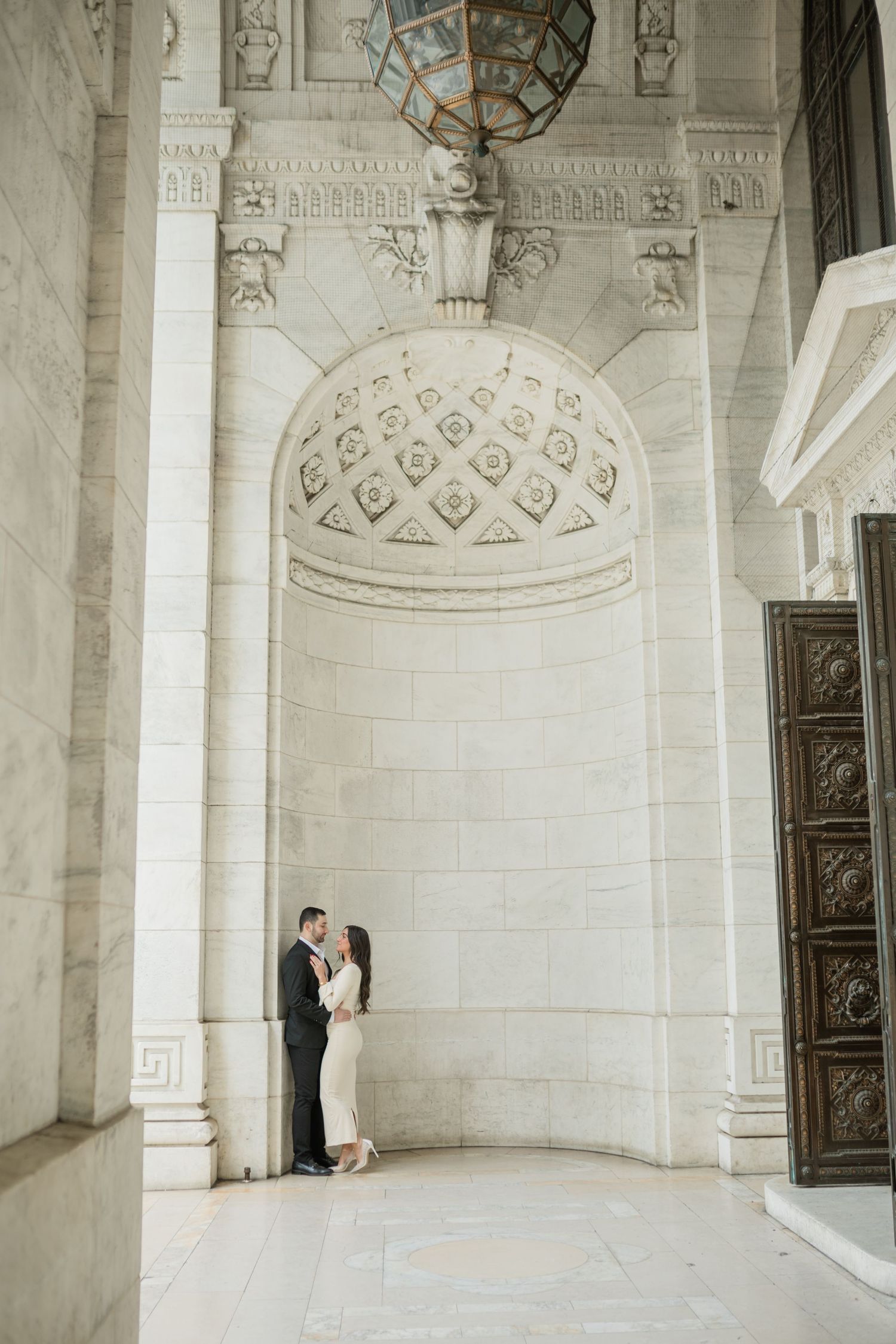 Elegant white marble interior with ornate architectural details and vaulted ceilings in a historic building.