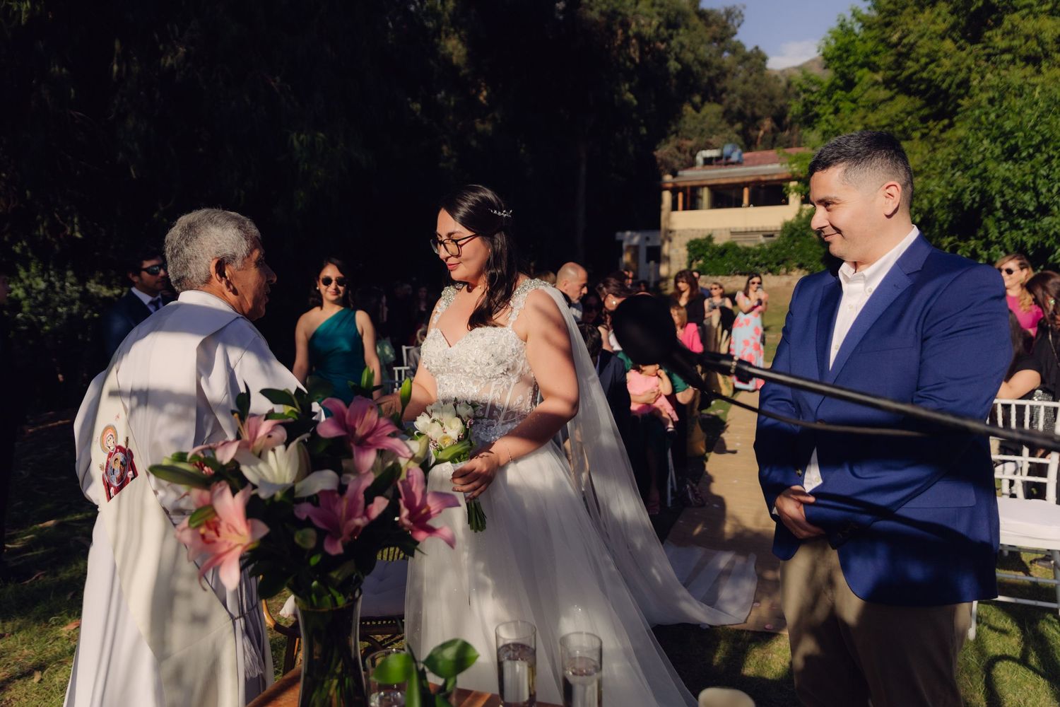 Bride and groom exchange vows with officiant at outdoor wedding.