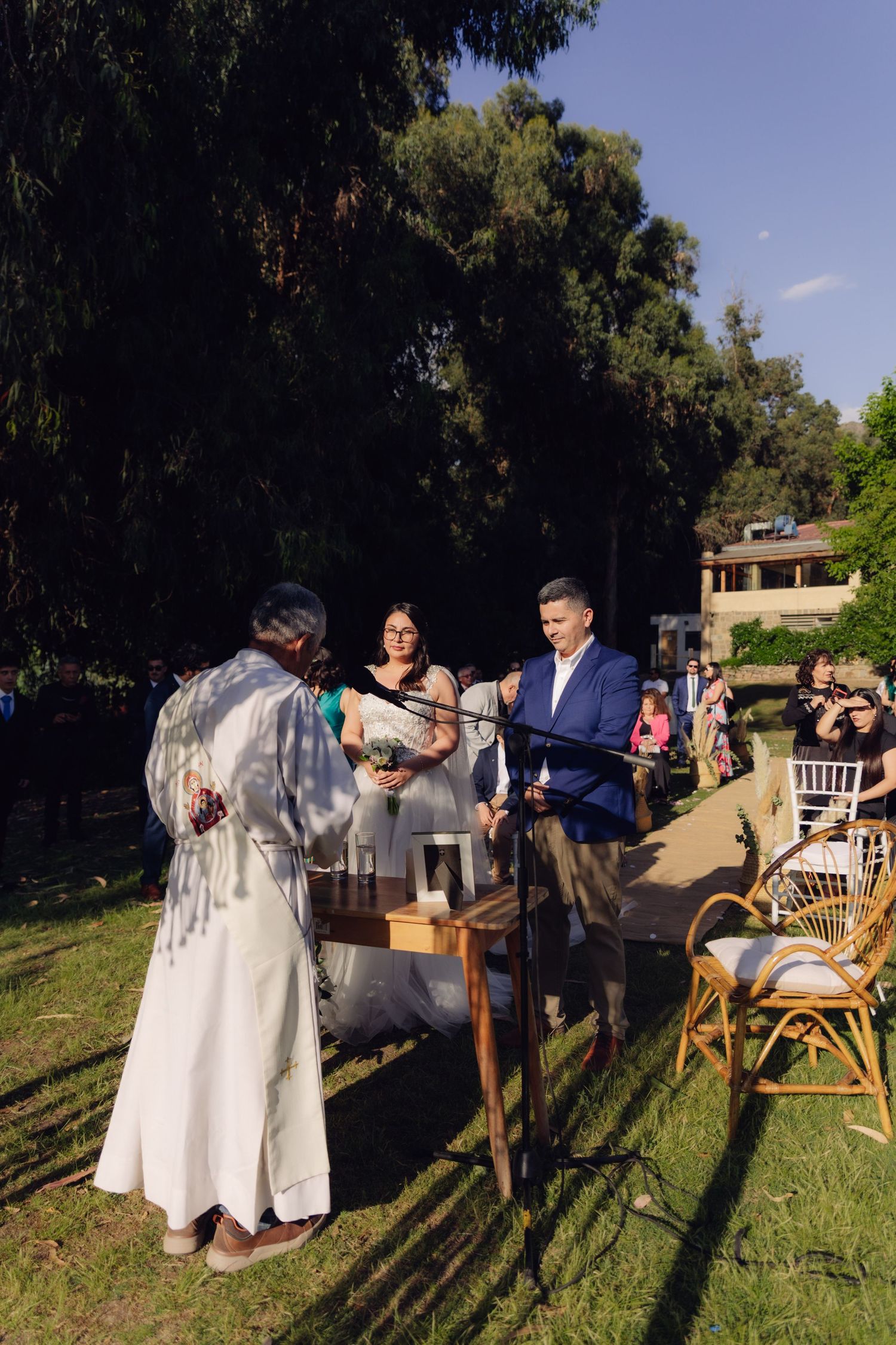 Officiant performs wedding ceremony for couple at outdoor garden venue.