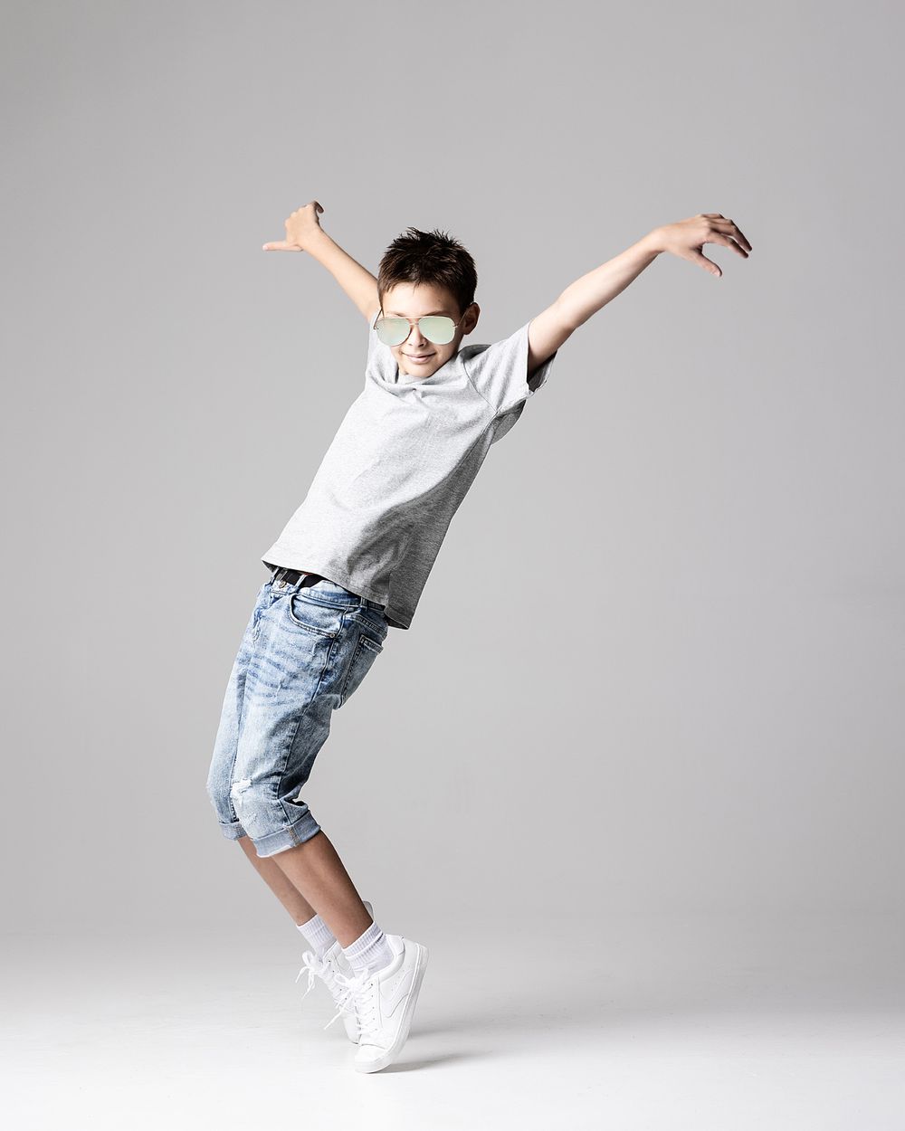 Boy wearing sunglasses posing in a photography studio for a modern back-to-school portrait session in Atlanta.