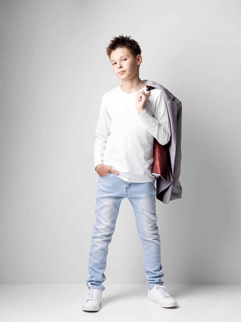Full-length portrait of a stylish boy wearing a blazer for a modern back-to-school photoshoot in Atlanta.
