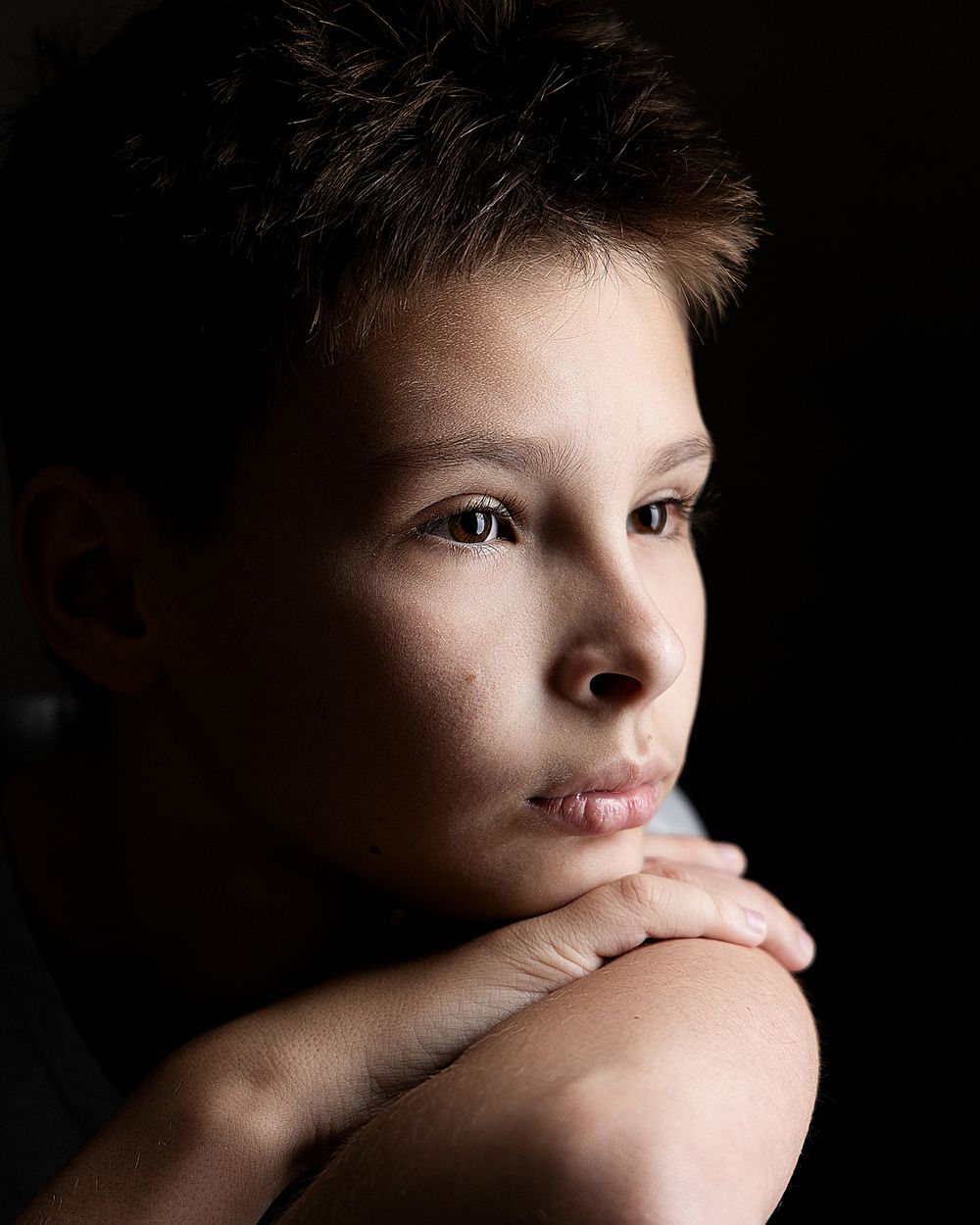 Close-up portrait of a thoughtful boy with natural window light during a back-to-school photography session in Atlanta.