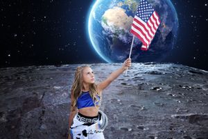 Young girl in a space-themed outfit holds an American flag on a moon surface with Earth glowing in the starry sky behind her.