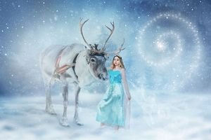 Girl in a flowing teal gown stands beside a white reindeer in a snowy winter fantasy scene with a swirling sparkling spiral.