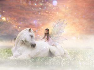 Little girl with fairy wings sits on a resting white unicorn in a dreamy meadow under a glowing pink and golden sky.