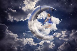 Woman in a blue dress sits on a crescent moon swing among fluffy clouds in a starry night sky fantasy scene.