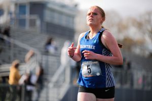 Athletes compete in a track and field event on a sunny day.